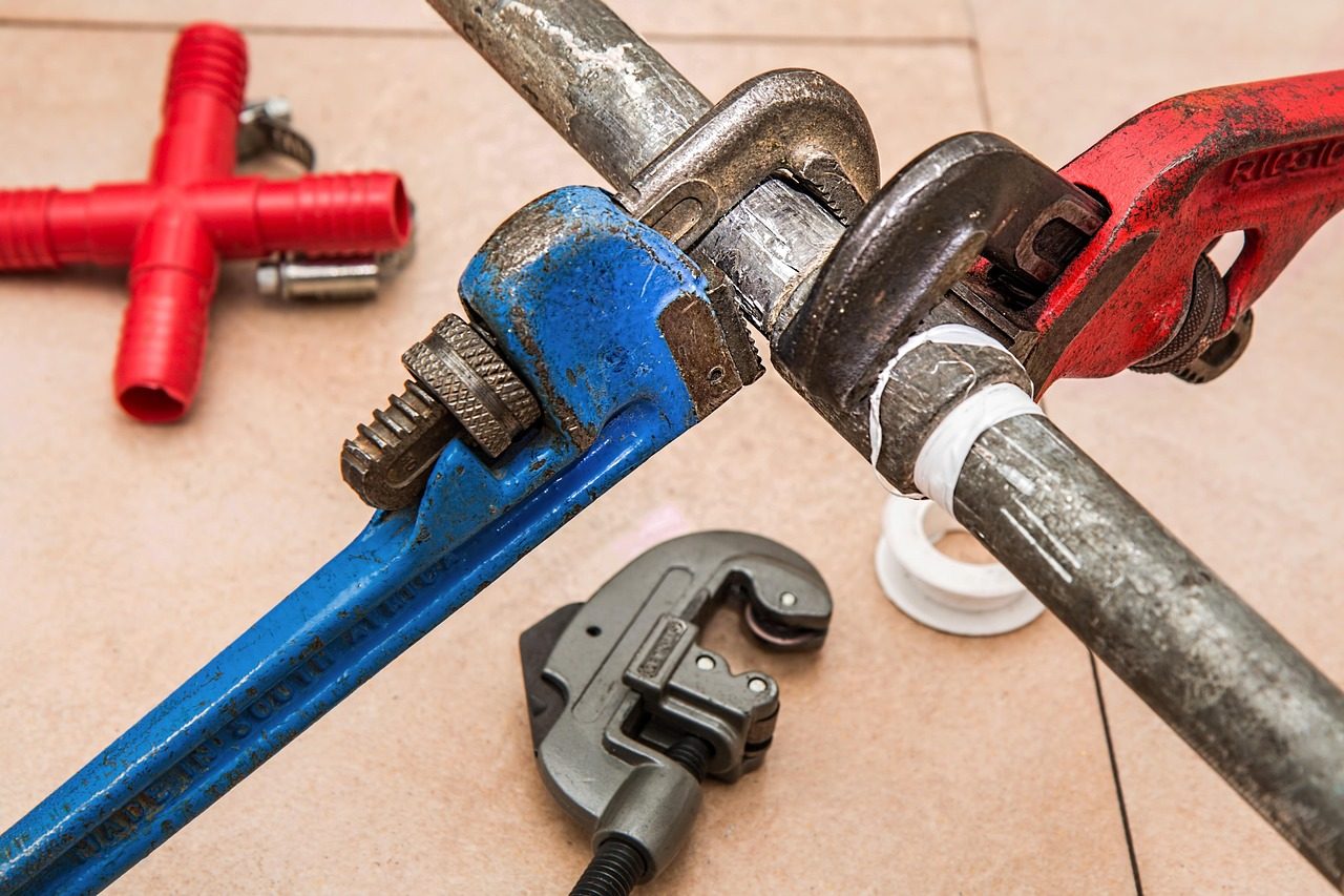 Pipe wrenches and fittings during an outdoor irrigation pipe repair